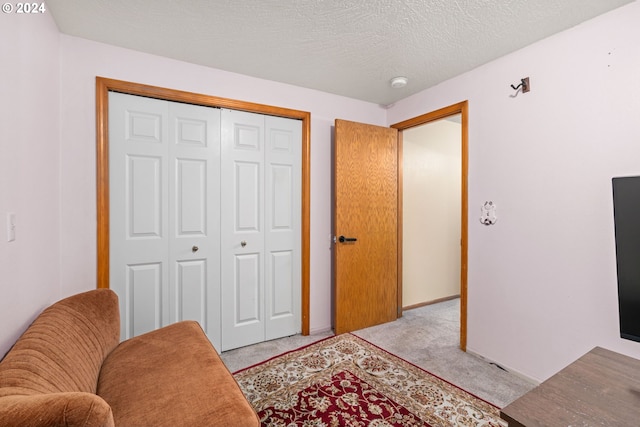 living area featuring light carpet and a textured ceiling