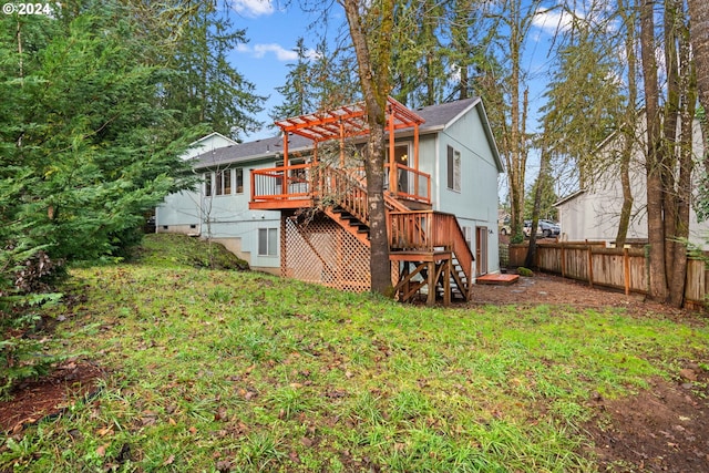 rear view of house featuring a pergola, fence, a yard, a wooden deck, and stairs