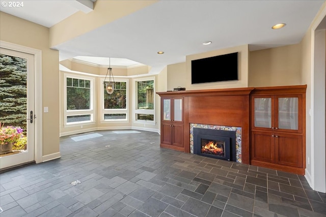 unfurnished living room with a fireplace, crown molding, plenty of natural light, and beamed ceiling