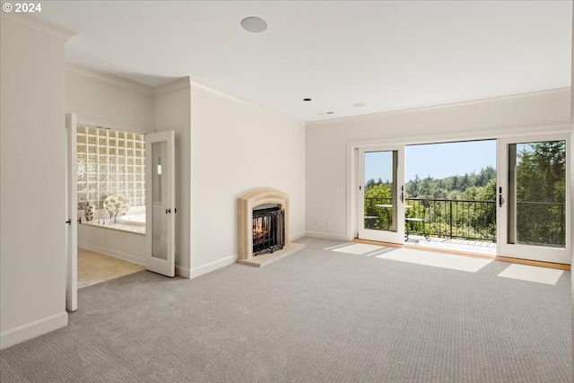 unfurnished living room with a wealth of natural light, ornamental molding, and light carpet