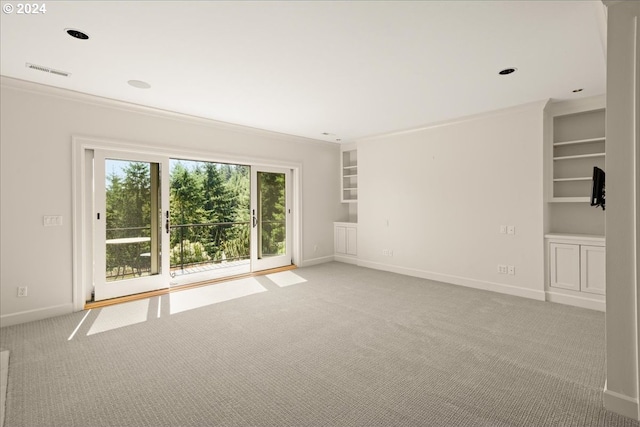 carpeted spare room featuring ornamental molding and built in features