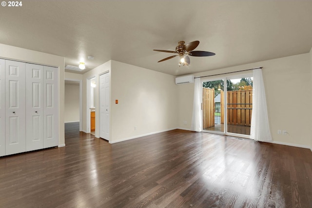 interior space with dark wood-type flooring, a wall mounted air conditioner, and ceiling fan