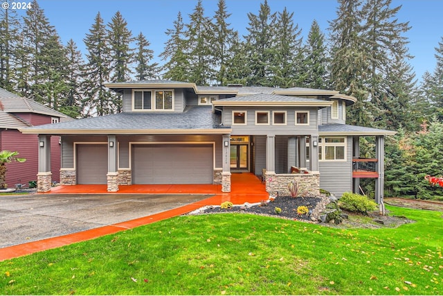 prairie-style house with covered porch, a front yard, and a garage