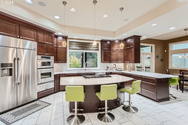 13829 SE Claremont St, Happy Valley, OR 97086 - kitchen with appliances with stainless steel finishes, light marble finish flooring, a sink, a peninsula, and light countertops