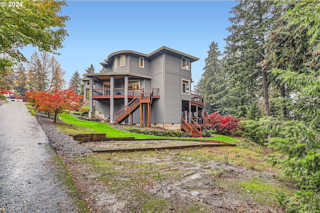 rear view of house featuring a wooden deck and a sunroom