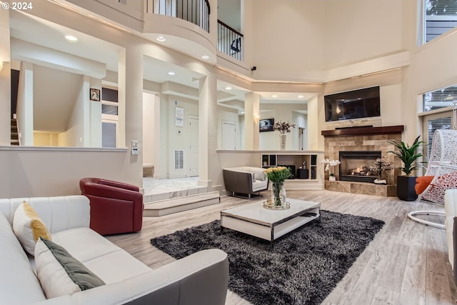 13829 SE Claremont St, Happy Valley, OR 97086 - living room featuring wood finished floors, a towering ceiling, and a lit fireplace