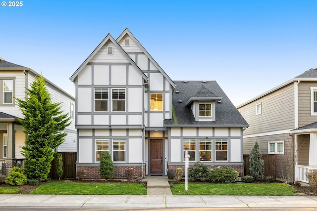 tudor-style house featuring a front lawn