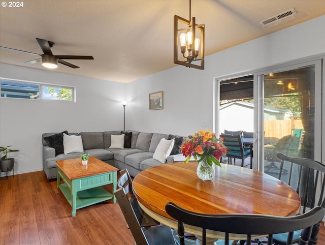 dining area featuring hardwood / wood-style floors, ceiling fan with notable chandelier, and a wealth of natural light