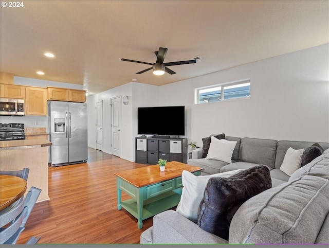 living room with ceiling fan and light hardwood / wood-style flooring