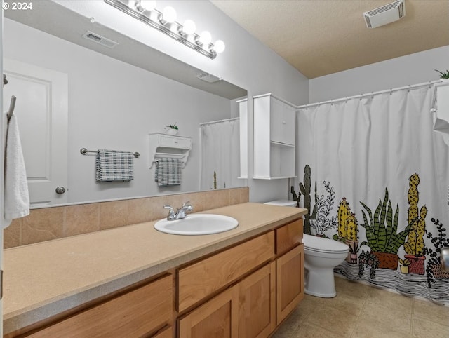 bathroom featuring tile patterned floors, vanity, a textured ceiling, and toilet