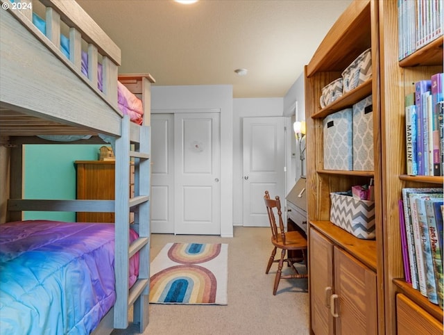 bedroom with light carpet and a closet