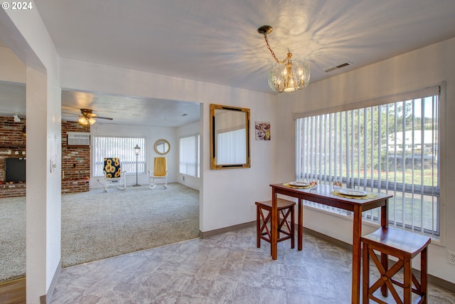 carpeted dining space featuring a wall unit AC, plenty of natural light, and ceiling fan with notable chandelier