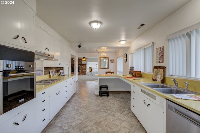 kitchen featuring white cabinets, sink, a fireplace, appliances with stainless steel finishes, and extractor fan