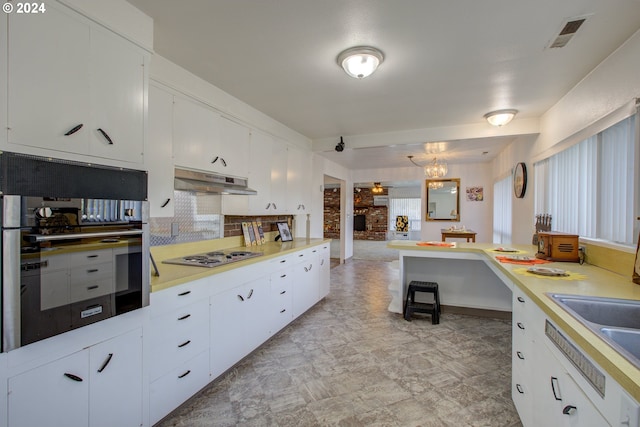 kitchen with white cabinets, exhaust hood, and gas stovetop