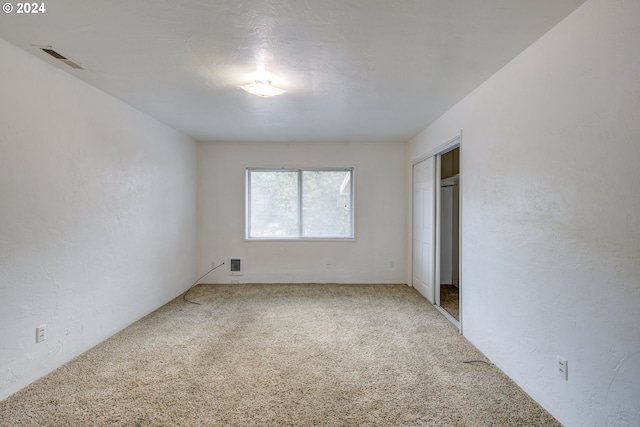 unfurnished bedroom featuring carpet floors and a closet