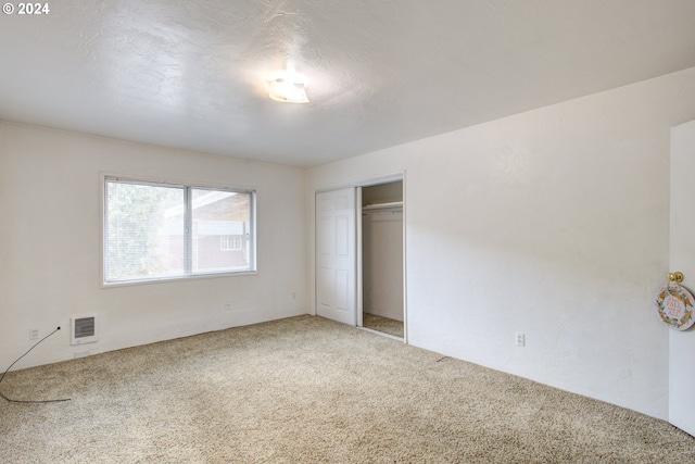 unfurnished bedroom with carpet flooring and a closet