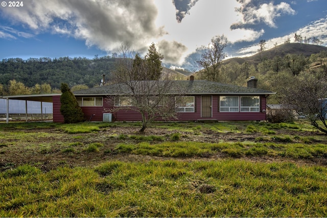 rear view of house featuring a carport and a mountain view