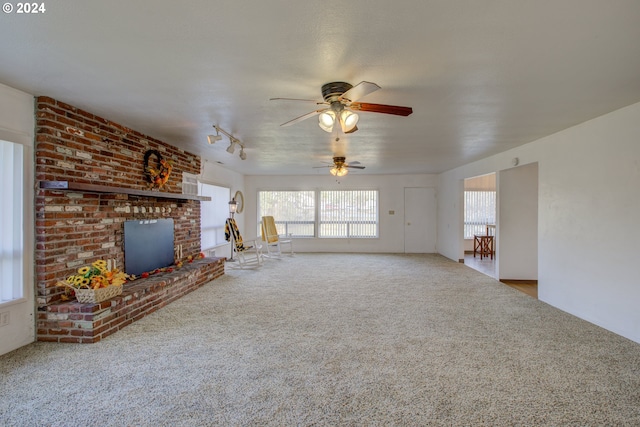 unfurnished living room featuring carpet flooring, ceiling fan, and a fireplace