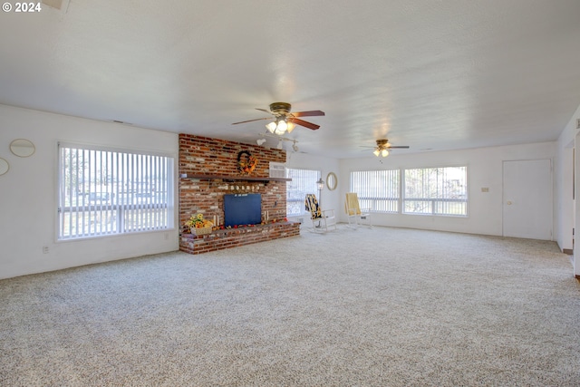 unfurnished living room featuring ceiling fan, a fireplace, and carpet floors