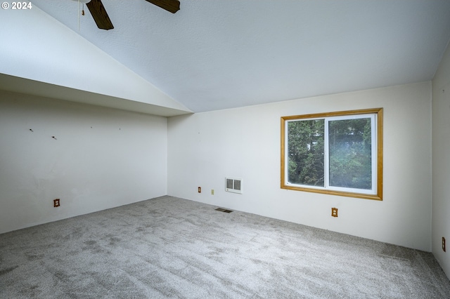 carpeted spare room featuring ceiling fan and vaulted ceiling