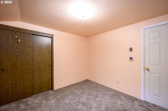 unfurnished bedroom with carpet, a textured ceiling, and a closet