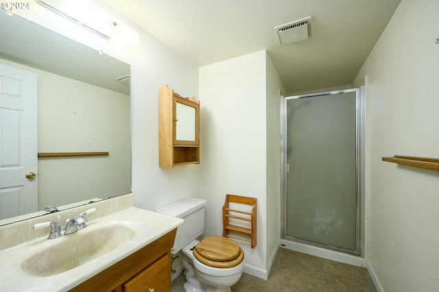 bathroom featuring vanity, toilet, and a shower with door