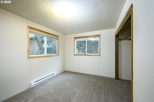 unfurnished bedroom with a closet, a baseboard radiator, a textured ceiling, and dark colored carpet