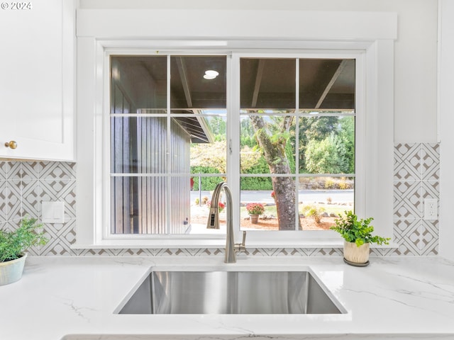 details featuring light stone counters and sink