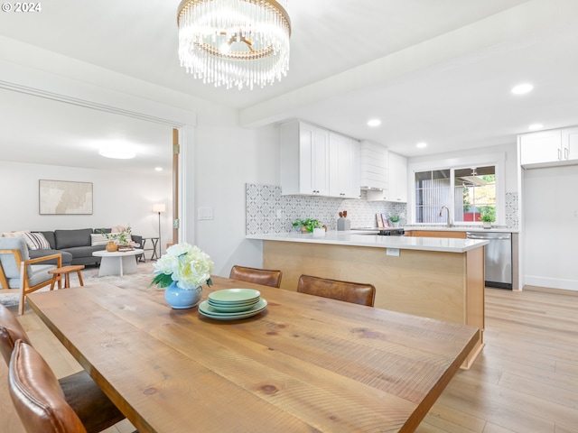 dining area featuring light hardwood / wood-style flooring and a chandelier