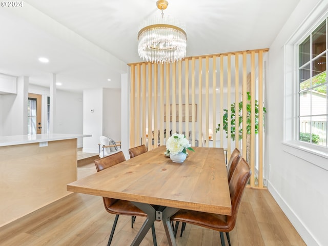 dining space featuring light hardwood / wood-style floors and an inviting chandelier