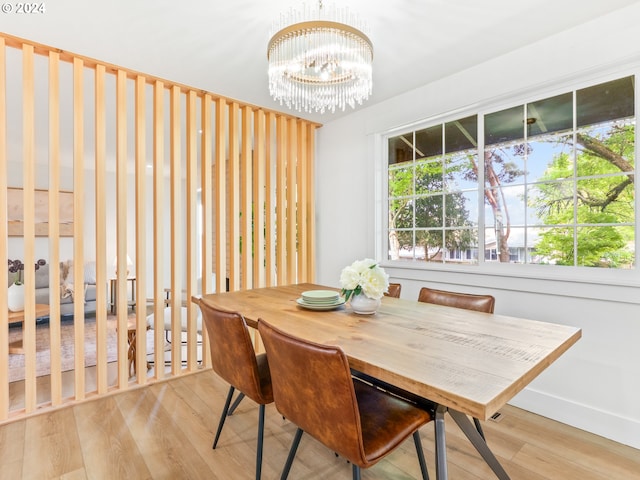 dining room with light wood-type flooring and a notable chandelier