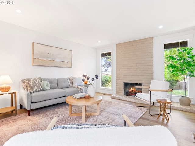 living room with light hardwood / wood-style floors and a brick fireplace