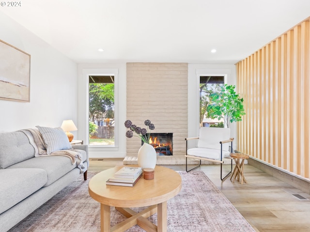 living room featuring hardwood / wood-style flooring and a large fireplace