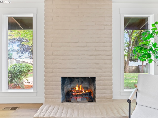 details featuring hardwood / wood-style floors and a brick fireplace