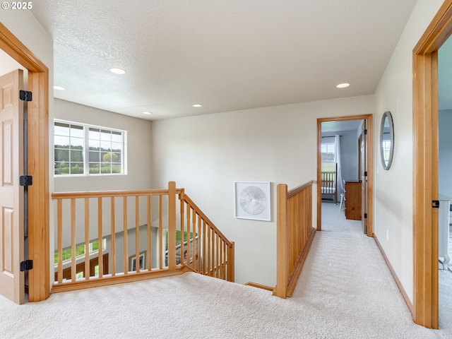 corridor featuring recessed lighting, baseboards, an upstairs landing, and carpet floors