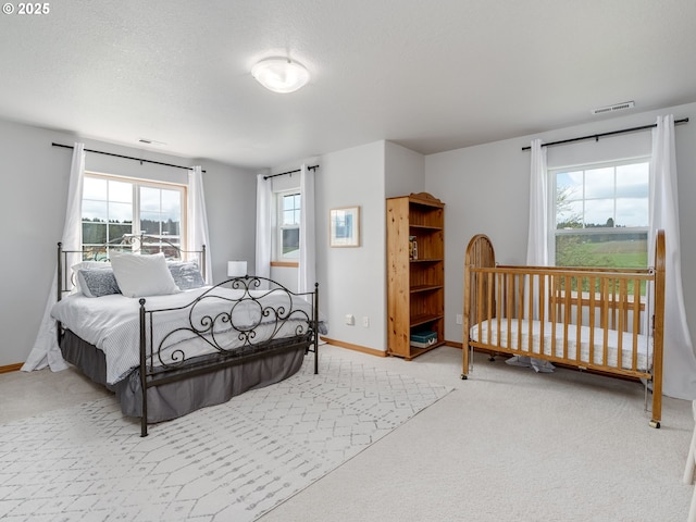bedroom with visible vents, baseboards, multiple windows, and carpet