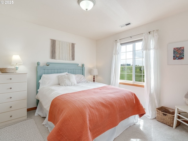 bedroom featuring visible vents, baseboards, and light carpet