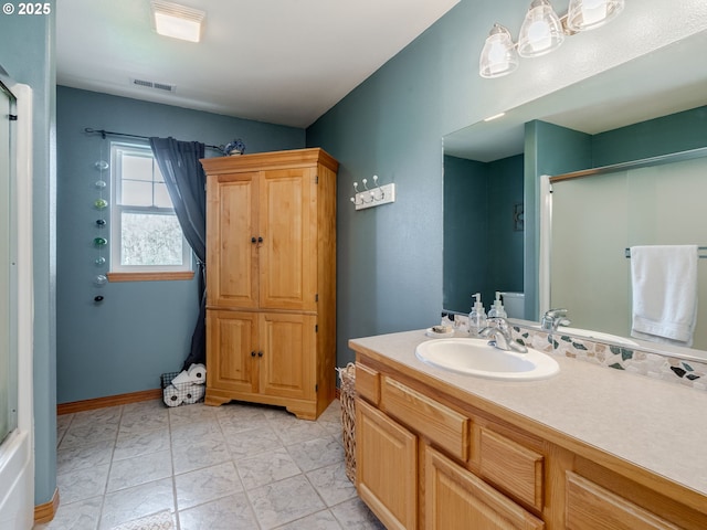 full bath with a shower with shower door, vanity, and visible vents