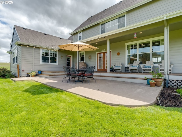 back of house with a yard, french doors, roof with shingles, and a patio area