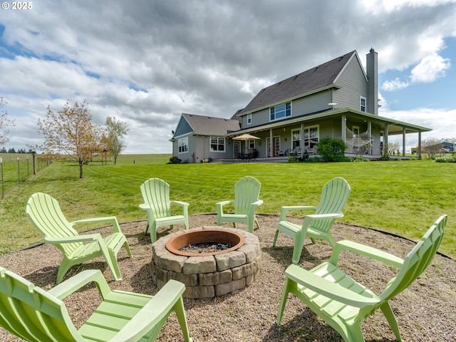 back of property featuring a yard, a patio, fence, a fire pit, and a chimney