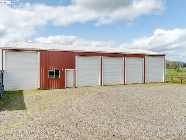 detached garage featuring driveway and fence