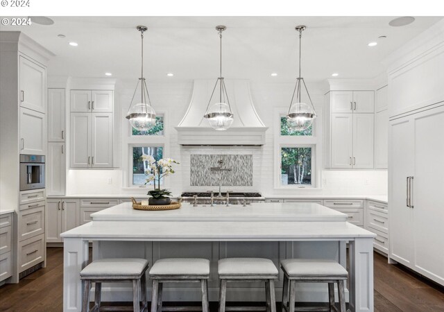 kitchen with dark wood-type flooring, light countertops, and backsplash