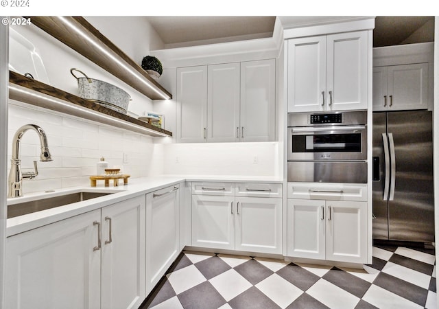 kitchen featuring white cabinets, sink, stainless steel appliances, and tasteful backsplash