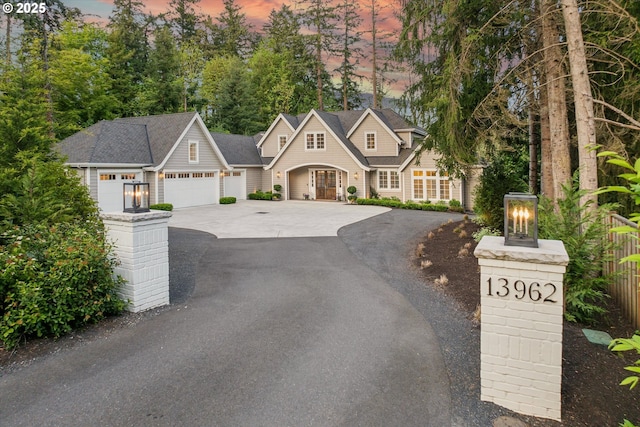 view of front of property featuring a garage, fence, and driveway