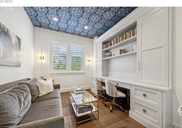 office space with baseboards, built in features, built in desk, an ornate ceiling, and dark wood-style floors