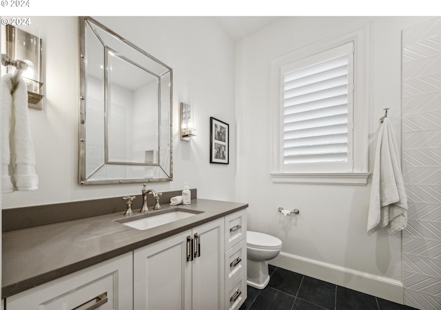bathroom featuring vanity, toilet, tile patterned flooring, and baseboards