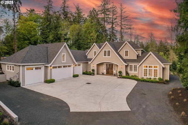 view of front of property featuring a garage, a shingled roof, and driveway