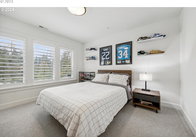 carpeted bedroom featuring visible vents, multiple windows, and baseboards