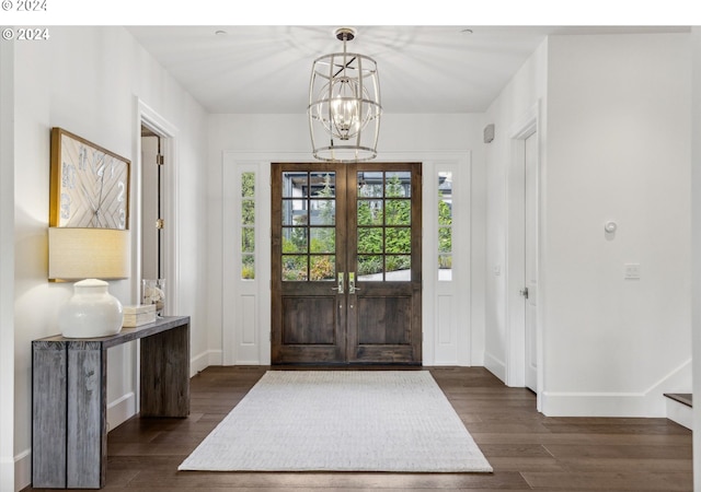 foyer with dark hardwood / wood-style flooring, french doors, and a chandelier