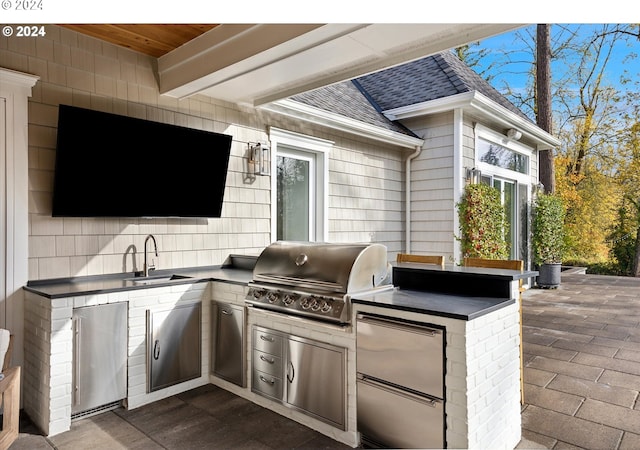 view of patio with a sink, area for grilling, and a grill